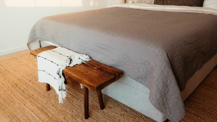 A bedroom with a simple color theme and a bench at Vignettes Home near Galena, IL, and Dubuque, IA