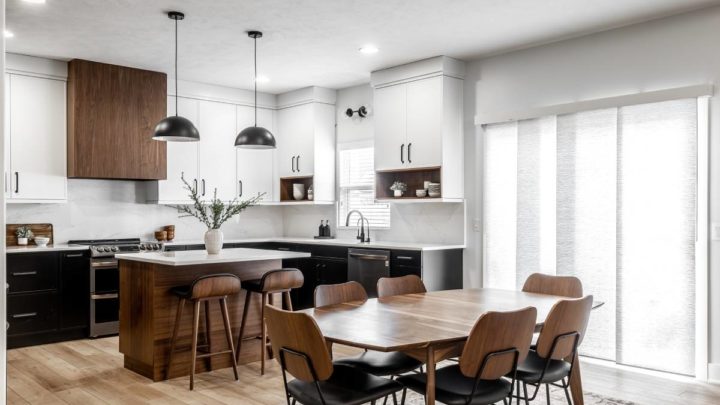 Dining room featuring a wood dining table and chairs, wood island, and vertical shades.