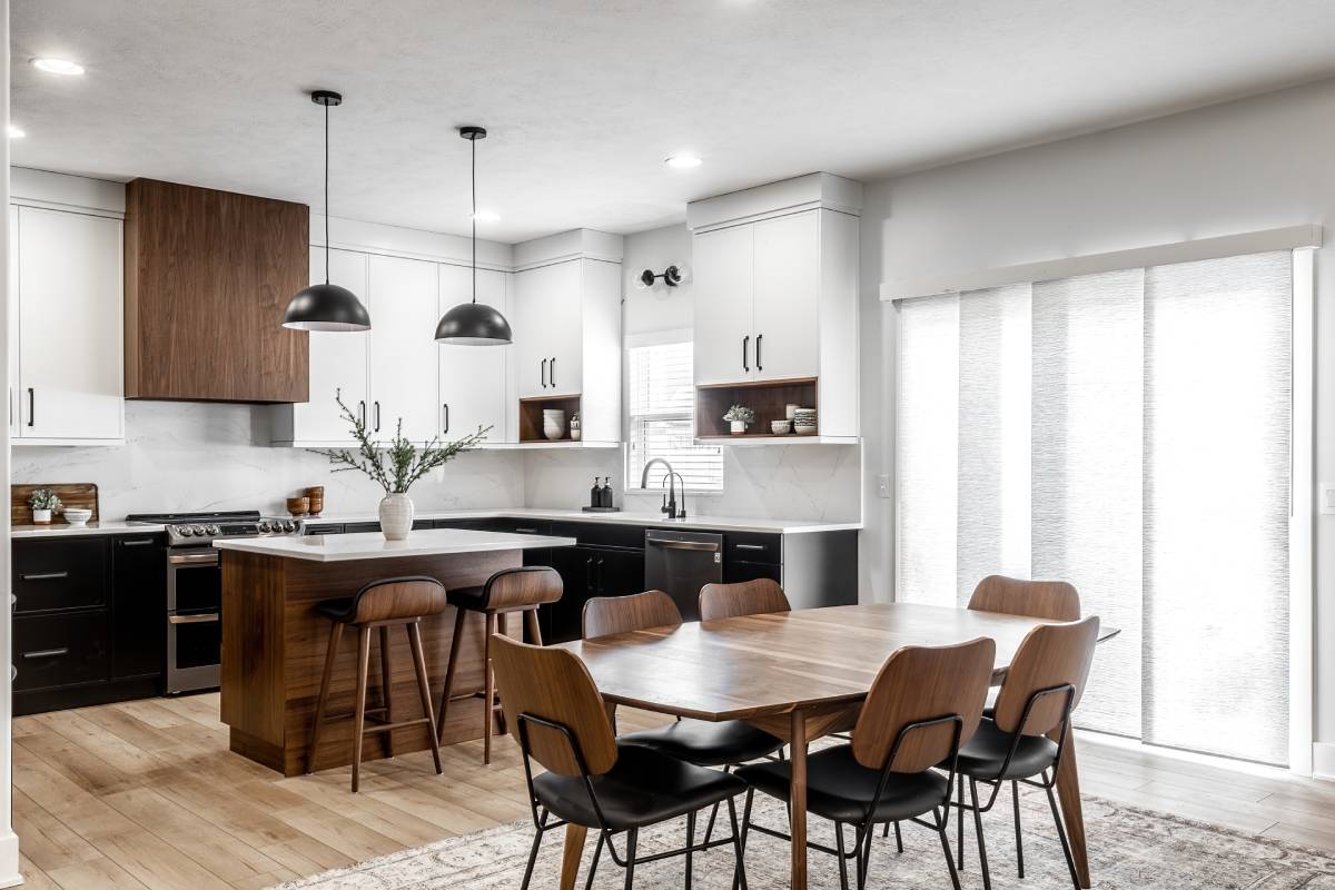 Dining room featuring a wood dining table and chairs, wood island, and vertical shades. 